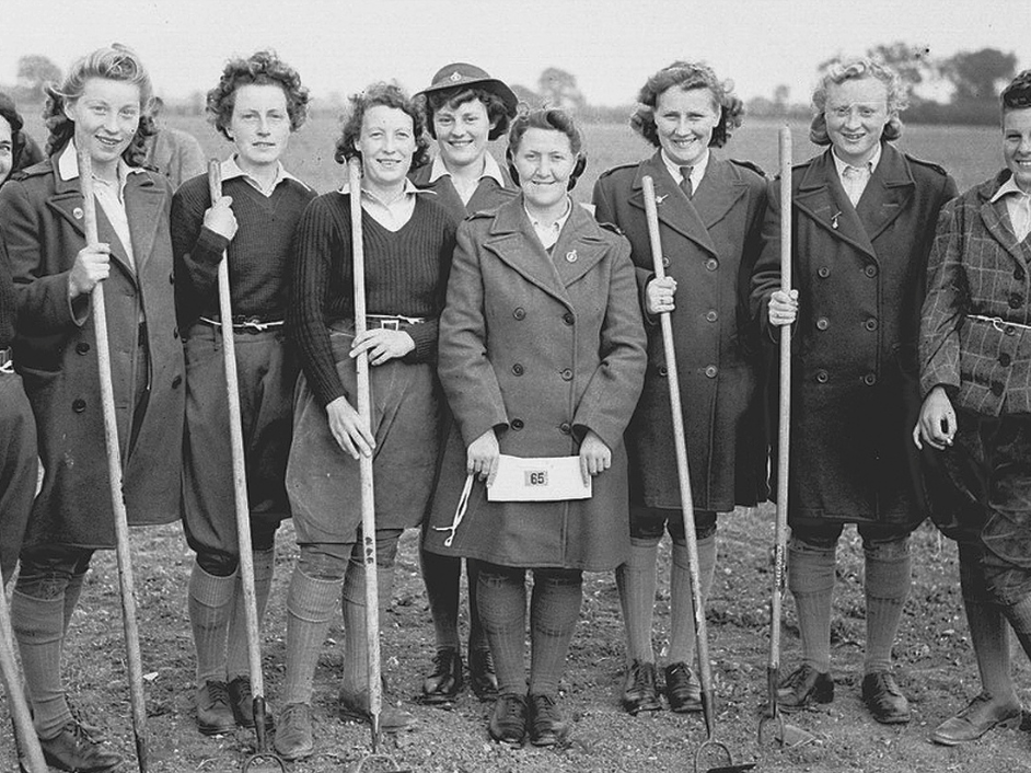 A group of Land Girls in uniform, holding shovels in a field at Hale Nursery, circa 1945.
